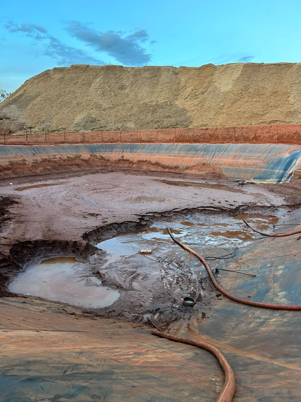 Lagoa com mangueiras durante serviço de limpeza