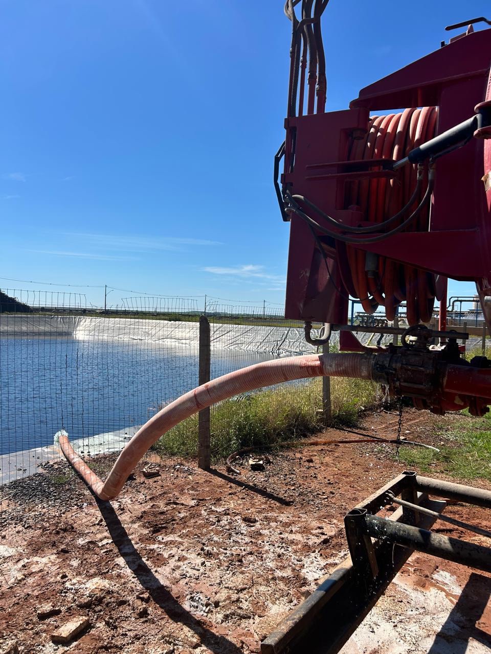 Equipamento e mangueira junto a uma lagoa